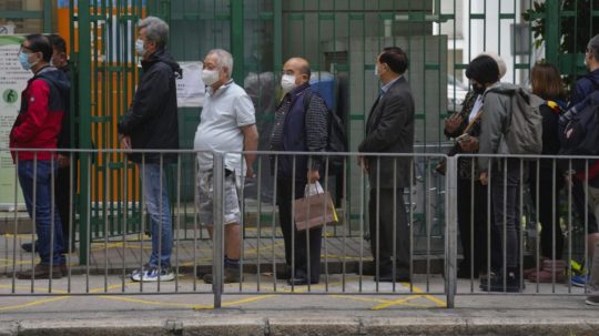 Ľudia čakajú pred volebnou miestnosťou počas volieb do legislatívnej rady (parlamentu) v Hongkongu