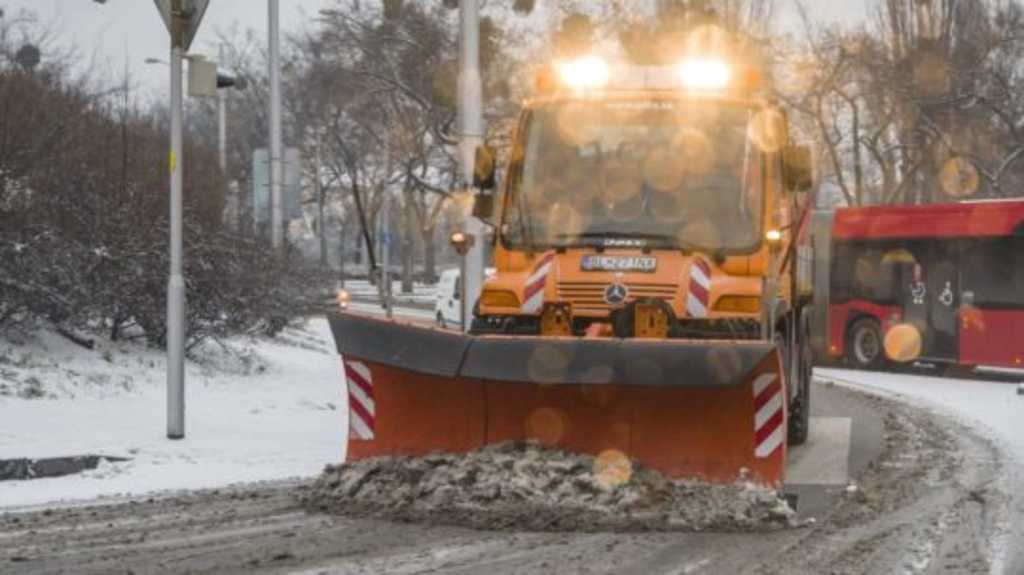 Na snímke pluh odhŕňa sneh z cesty.