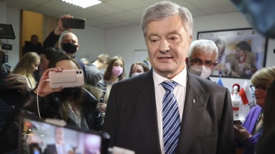 Bývalý ukrajinský prezident Petro Porošenko prechádza okolo novinárov vo Varšave.