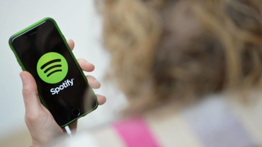 žena drží v ruke mobil s aplikáciou Spotify