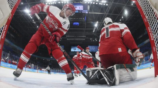 Dánsky hráč Jesper Jensen Aabo (vľavo) zastavuje puk pred dánskym brankárom Frederikom Dichowom.