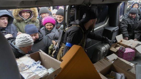 Obyvatelia Buče stoja v rade na humanitárnu pomoc.