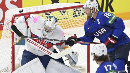 Na snímke zľava britský brankár Jackson Whistle, americký hráč Austin Watson a dole jeho spoluhráč Adam Gaudette v zápase základnej B-skupiny Veľká Británia - USA.