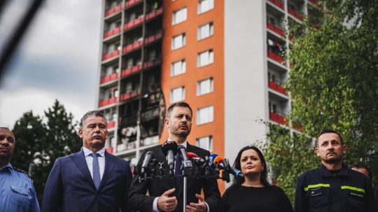 Premiér Eduard Heger (OĽANO) a minister vnútra Roman Mikulec pri obhorenom bytovom dome v Handlovej.