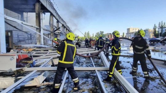 Na snímke z videozáznamu hasiči pracujú na hasení požiaru v obchodnom centre, ktoré vyhorelo po raketovom útoku v Kremenčuku na Ukrajine.