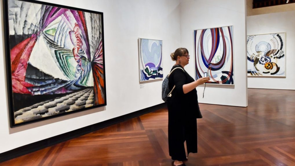 Na sn&iacute;mke stoj&iacute; žena v gal&eacute;rii vystavuj&uacute;cej obrazy česk&eacute;ho maliara Franti&scaron;ka Kupku.