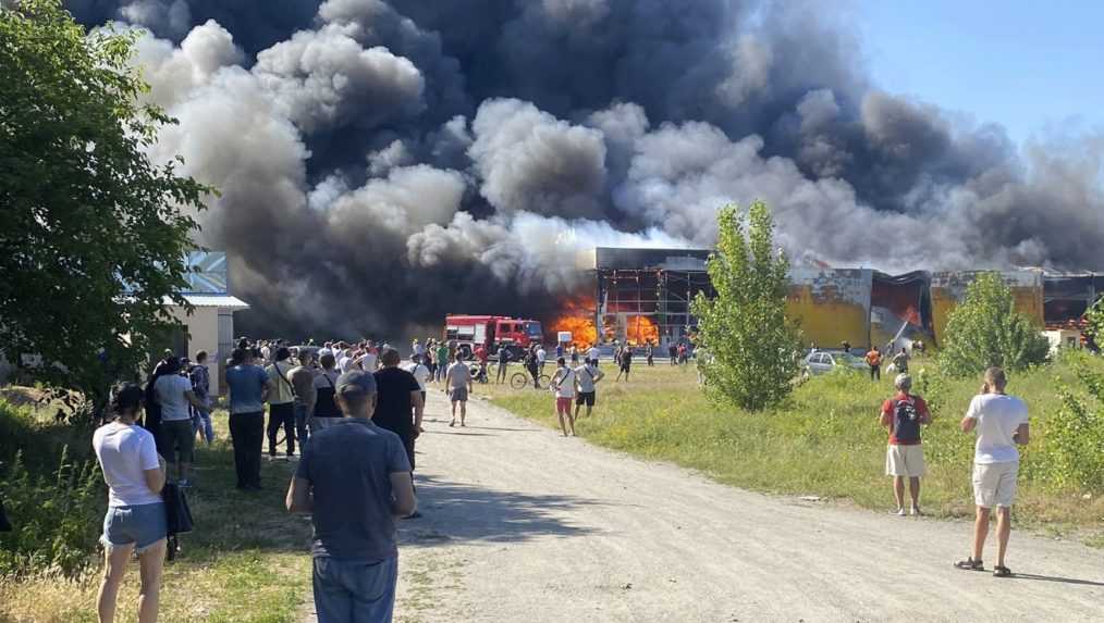 Kremenčuk - ľudia sledujú hustý čierny dym po ruskom raketovom útoku na nákupné centrum v ukrajinskom meste Kremenčuk 27. júna 2022. Ukrajinský prezident Volodymyr Zelenskyj označil pondelkový raketový útok Ruska na nákupné centrum v ukrajinskom meste Kremenčuk za "bezočivý teroristický čin". Zelenskyj predtým vyhlásil, že v nákupnom centre sa v čase útoku nachádzalo viac než tisíc civilistov.