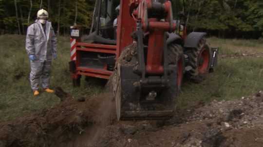 Na snímke bager a muž v ochrannom