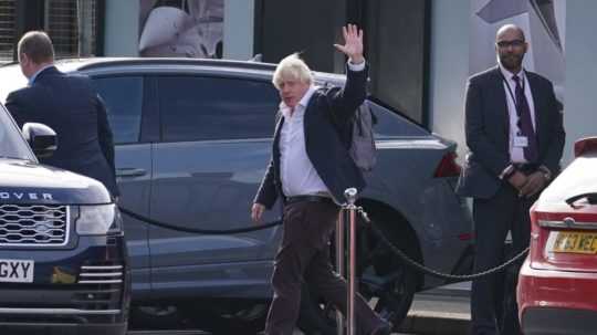 Bývalý britský premiér Boris Johnson máva počas jeho príchodu na letisko Gatwick v Londýne po prílete z Karibiku.