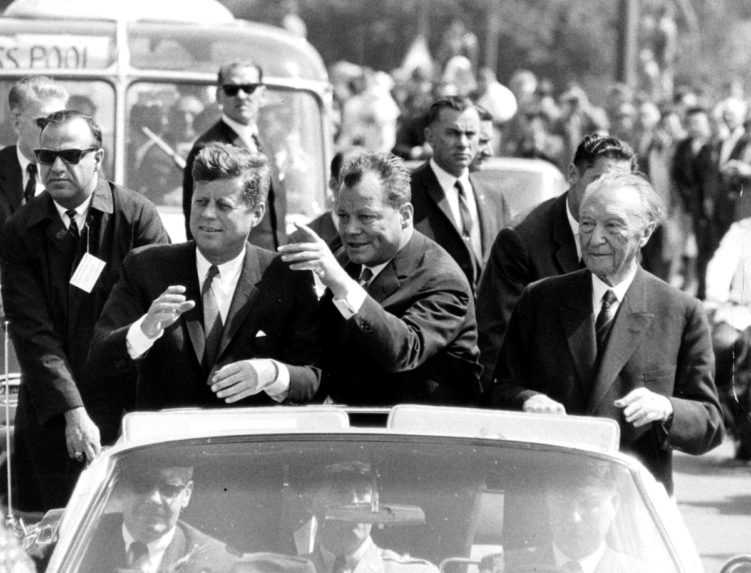 Starosta Západného Berlína Willy Brandt (uprostred), americký prezident John F. Kennedy (vľavo) a nemecký kancelár Konrad Adenauer v Berlíne (1963).
