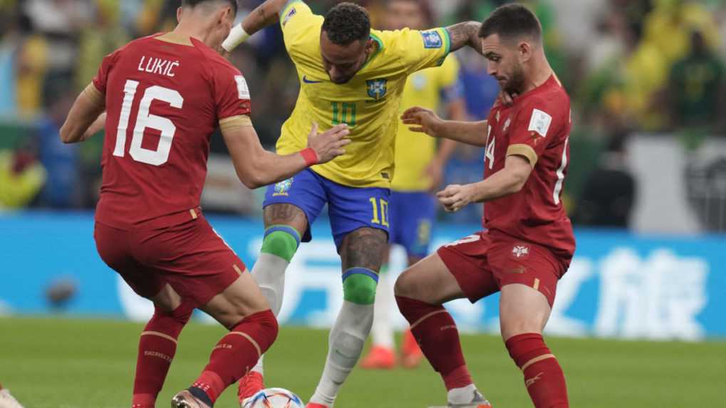Brazílsky futbalista Neymar (uprostred) a srbskí hráči Andrija Živkovič (vpravo) a Saša Lukič (vľavo) bojujú o loptu v zápase.