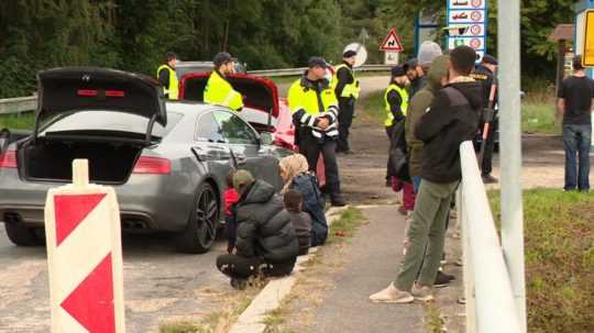 Na snímke českí policajti a zadržaní nelegálni migranti.