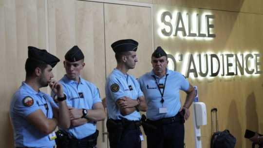 Policajti dohliadajú na poriadok v súdnej sieni.