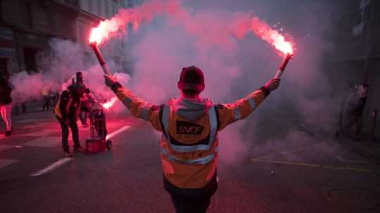 Na snímke železničiar drží svetlice počas štrajku v Marseille.