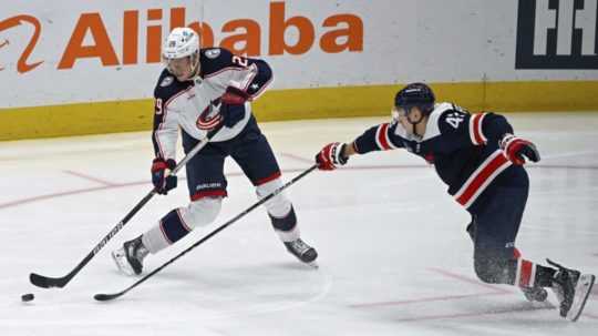 Útočník Columbusu Blue Jackets Patrik Laine (vľavo) v súboji so slovenským obrancom Martinom Fehérvárym z Washingtonu Capitals.