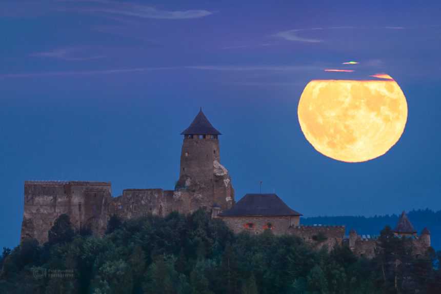 Mesiac v splne vychádzajúci nad hradom Ľubovňa na východnom Slovensku.