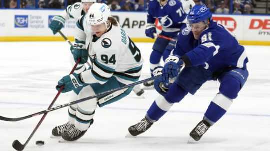 Slovenský hokejový obranca v drese Tampy Bay Lightning Erik Černák (vpravo) a hráč San Jose Sharks Alexander Barabanov bojujú o puk v zápase zámorskej hokejovej NHL Tampa Bay Lightning - San Jose Sharks.