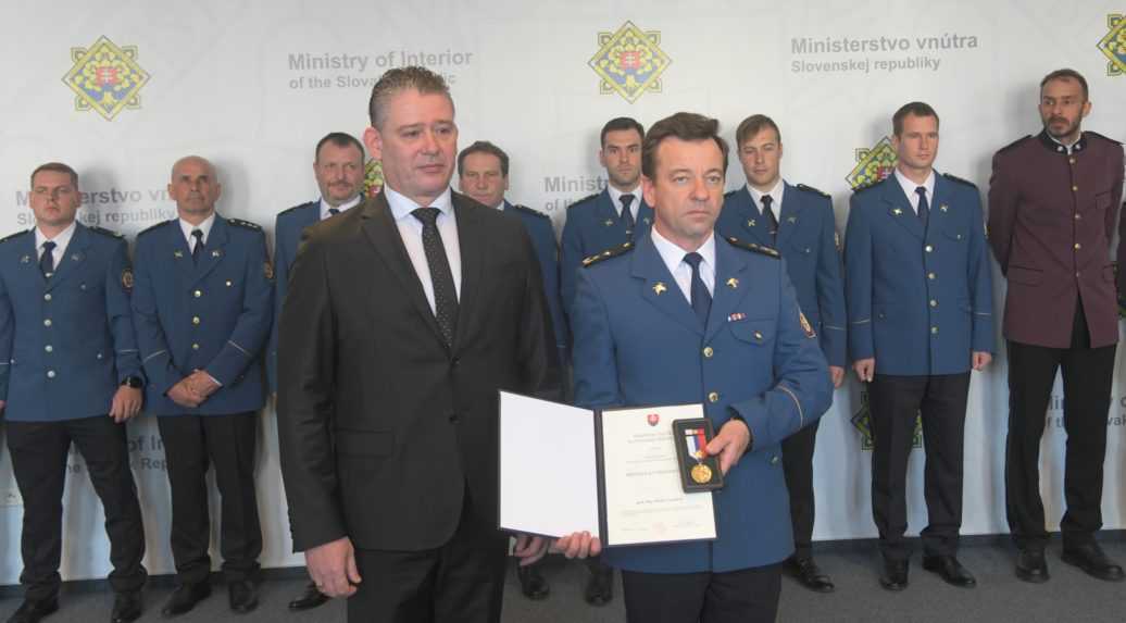 Jeden z členov záchranného tímu si preberá medailu od dočasne povereného ministra vnútra Mikulca.