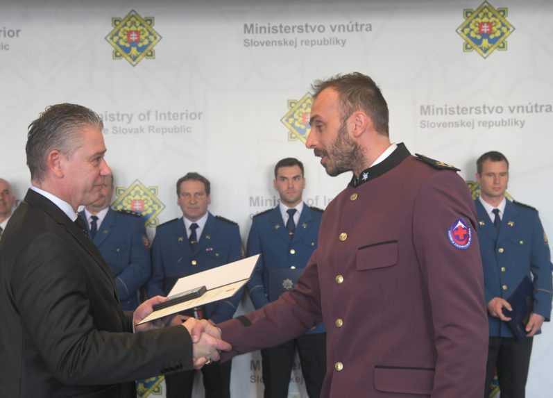 Jeden z členov záchranného tímu si preberá medailu od dočasne povereného ministra vnútra Mikulca.