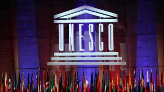 Logo UNESCO a členské vlajky.