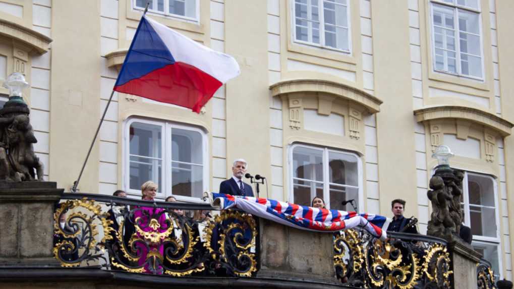 Český prezident Petr Pavel s manželkou Evou zdravia ľudí z balkóna na Treťom nádvorí Pražského hradu.
