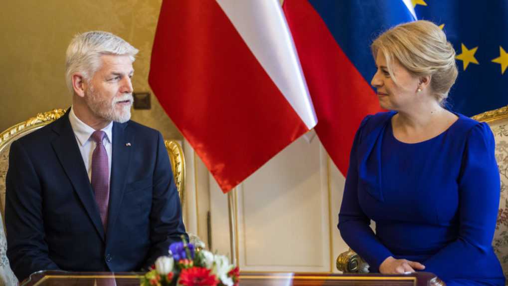 Na snímke sedia zľava český prezident Petr Pavel v obleku a Zuzana čaputová v kráľovsky modrých šatách, Na stole je kytička kvetov