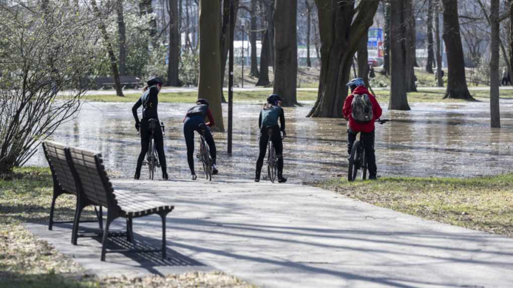 Na snímke štyria cyklisti stoja pred vodou v sade Janka Kráľa