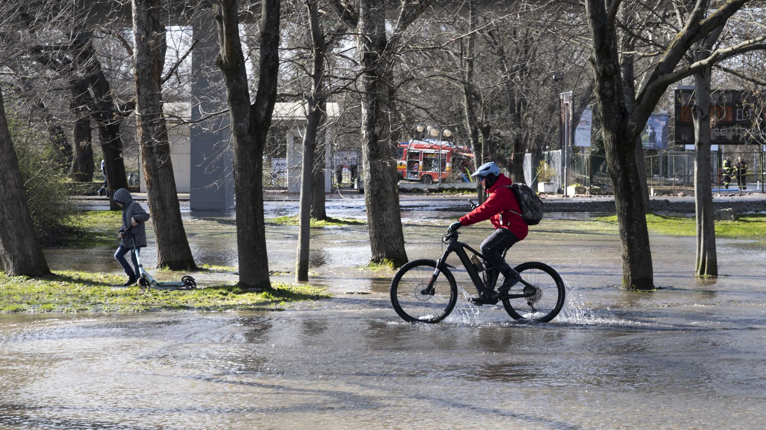 Na snÃƒÂ­mke cyklista jazdÃƒÂ­ cez zaplavenÃƒÂº Ã„ÂasÃ…Â¥ Sadu Janka KrÃƒÂ¡Ã„Â¾a.