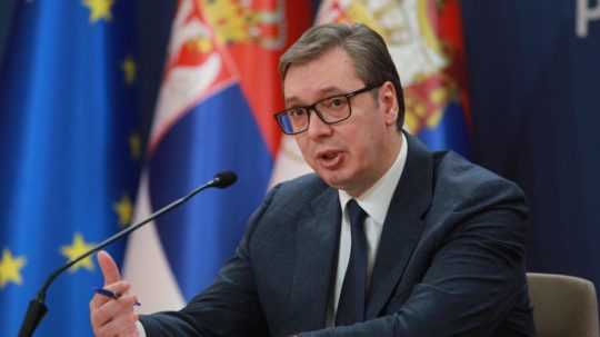 Srbský prezident Aleksandar Vučič, za ním srbská vlajka.