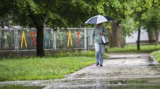 Na snímke žena s dáždnikom kráča počas dažďa v bratislavskej mestskej časti Ružinov.