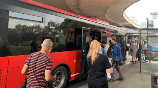 Cestujúci nastupujú na autobusovej zastávke pod Mostom SNP do autobusu na linke číslo 901.