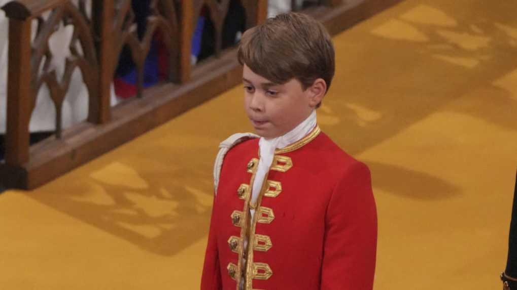 Princ George drží lem rúcha počas korunovácie britského kráľa Karola III.
