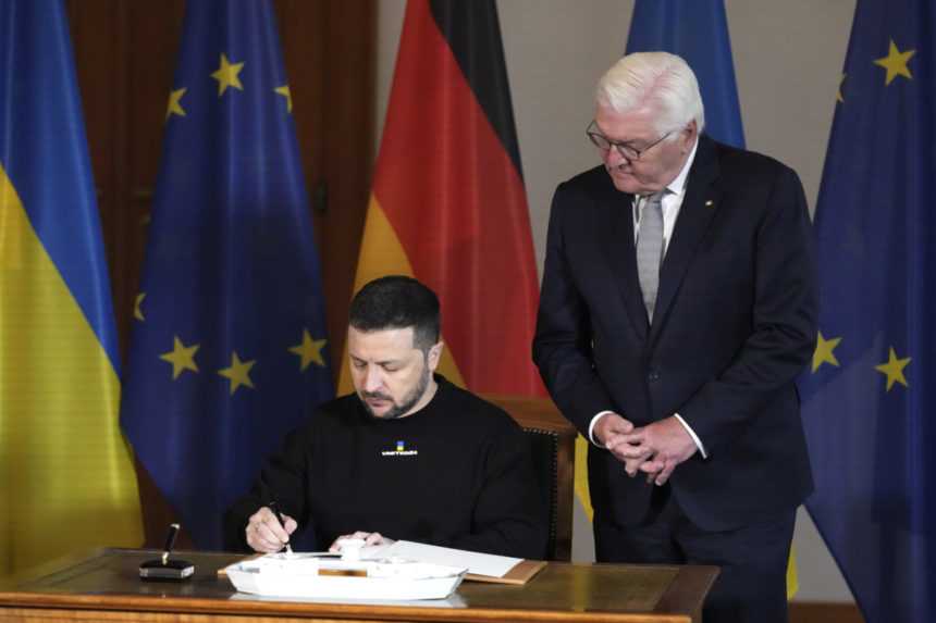 Ukrajinský prezident Volodymyr Zelenskyj sa zapisuje do návštevnej knihy počas stretnutia s nemeckým prezidentom Frankom-Walterom Steinmeierom 14. mája 2023 v Berlíne.