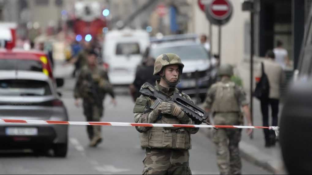 Vojak hliadkuje pred policajnou páskou po výbuchu.