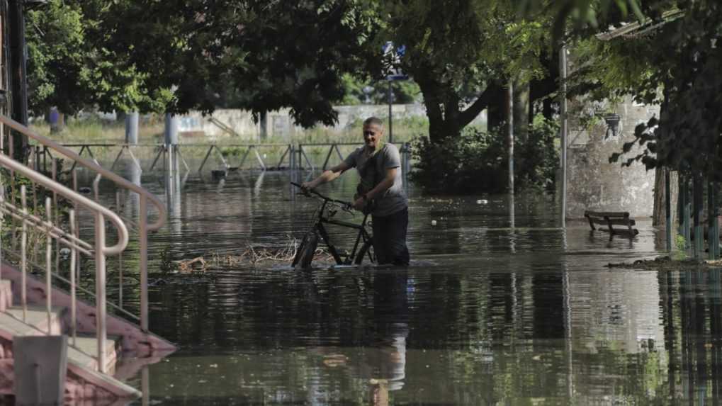 Obyvateľ Chersonu prechádza zatopenou ulicou s bicyklom.