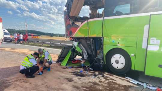 Pracujúci muži pri havarovanom autobuse.