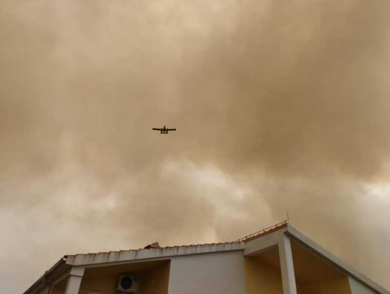 Z požiaru sa šíri hustý dym, hasiť pomáhajú aj lietadlá.