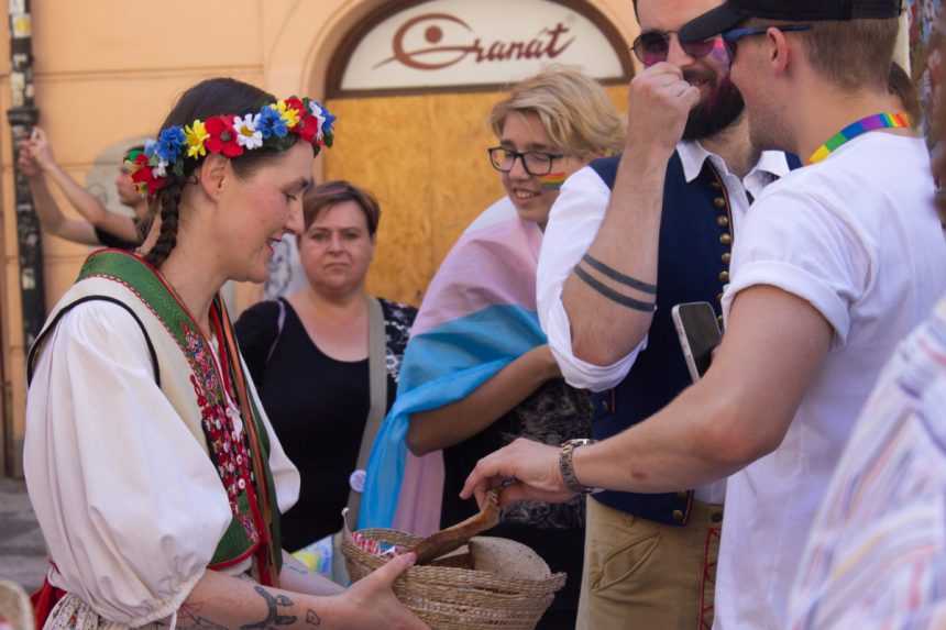 Účastníčka pochodu Prague Pride 2023 ponúka ostatným chlieb. Témou tohto ročníka boli totiž tradície.