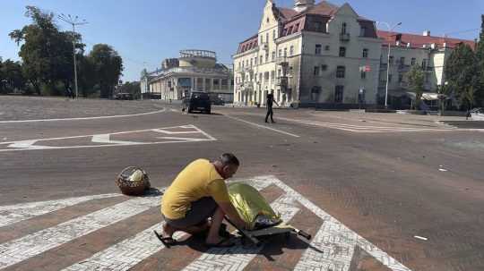 Muž zakrýva mŕtve telo po ruskom útoku v ukrajinskom Černihive.