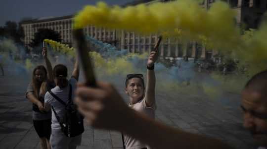 Žena drží pochodeň na proteste.