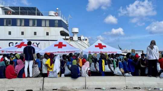 Skupina migrantov čaká na sicílskom ostrove Lampedusa.