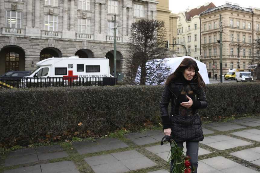 Žena prináša kyticu k pietnemu miestu na námestí Jana Palacha neďaleko FF UK.