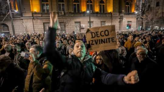 Muž hádže vajce na budovu volebnej komisie počas protestu stúpencov srbskej opozície v Belehrade.