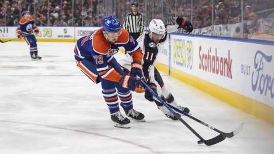 Adam Fantilli (11) z Columbusu Blue Jackets a Vincent Desharnais (73) z Edmontonu Oilers sa snažia získať puk.