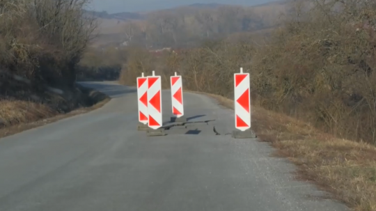 Prepadnutá cesta obkolesená dopravným značením.