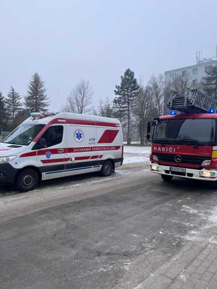 Sanitka a hasičské auto pred bytovkou v Rožňave.