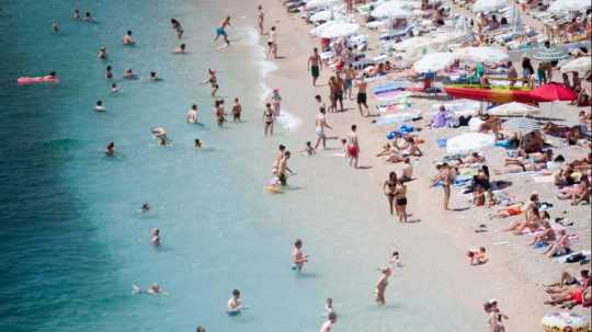 Turisti na pláži v chorvátskom Dubrovníku.