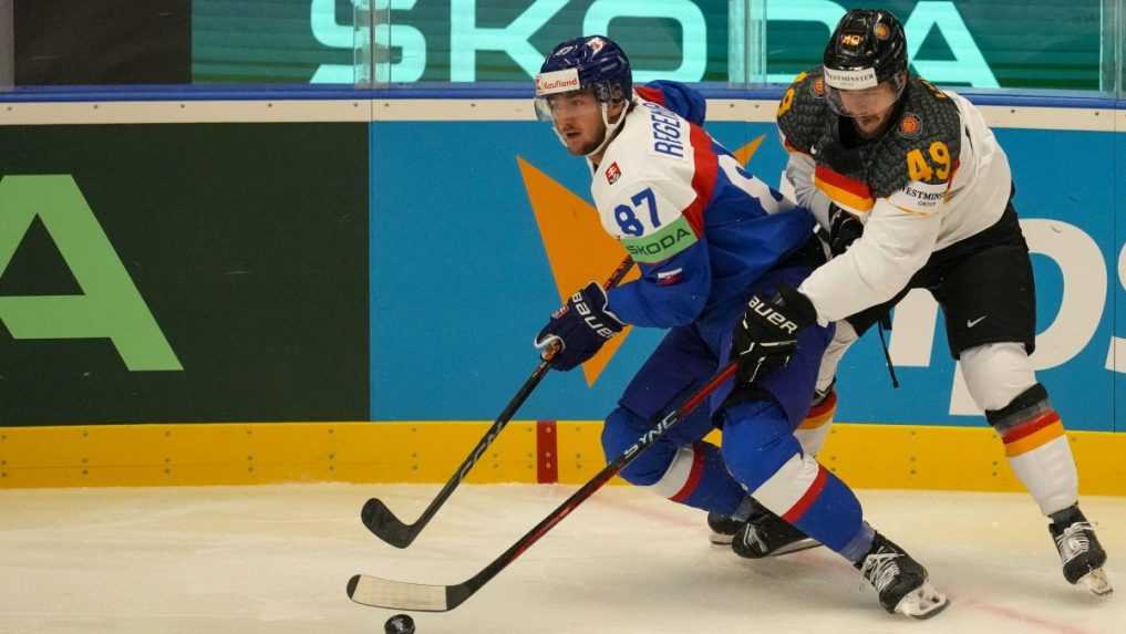 Slovenský hokejista Pavol Regenda (vľavo) a hráč Nemecka Lukas Kälble bojujú o puk.