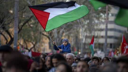 Chlapec máva palestínskou vlajkou počas pochodu demonštrantov počas protestu na podporu Palestínčanov a výzvy na okamžité prímerie v Gaze v Barcelone 20. januára 2024.