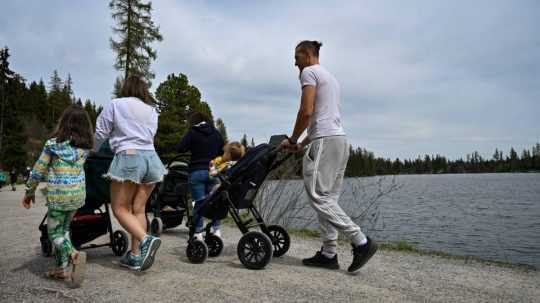 Turisti sa prechádzajú okolo Štrbského plesa.